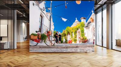 Classical bicycle parked in the middle of the old town surrounded with flowers and trafitional Greece, Italian style. Wall mural