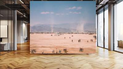 Nevada desert, USA. The national life festival. People walking down the desert exploring different art sculptures and riding bicycles. Sunset time. Wall mural