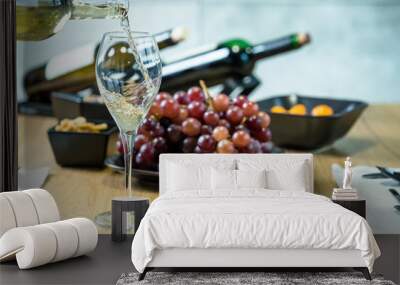 Pouring wine into glass and food background Wall mural