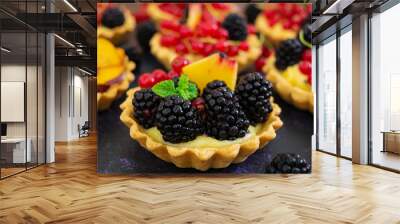 Tartlets with different berries on dark background Wall mural