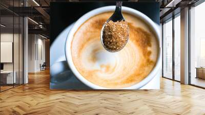 pouring brown sugar in cappuccino Wall mural