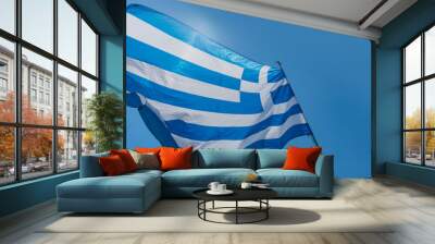 Waving Greek flag against a clear blue sky during a sunny day Wall mural