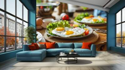 A photo of an egg and salad breakfast, featuring eggs sunny side up on plates with fresh vegetables like lettuce, tomatoes, avocados Wall mural