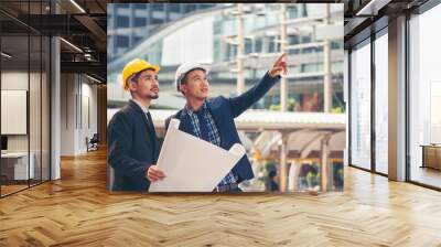 Civil engineer teams meeting working together wear worker helmets hardhat on construction site in modern city. Foreman industry project manager engineer teamwork. Asian industry professional team Wall mural