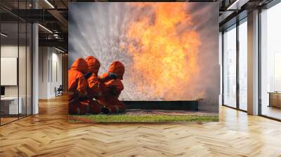 Firefighter Rescue training in fire fighting extinguisher. Firefighter fighting with flame using fire hose chemical water foam spray engine. Fireman wear hard hat, safety suit uniform for protection Wall mural