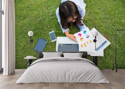 Top view asian entrepreneur business woman reading business graph analyze chart using laptop on green garden at home. Freelance working home office social distance new normal lifestyle in green park Wall mural