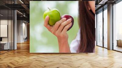 Young asian woman eating hand holding green red apple Healthy smiling face teeth. Girl workout holding organic apple fruit healthy lifestyle. Wellness women eat red apple smile face look at camera Wall mural