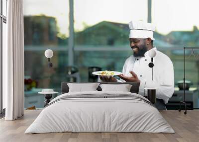 African American chef with plate of tasty salad in kitchen Wall mural