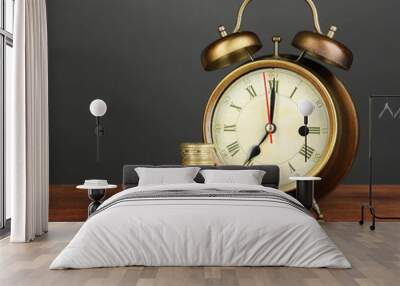 Antique clock and coins on wooden table on black background Wall mural