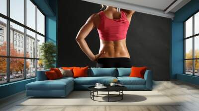 Athletic woman with dumbbells on dark background Wall mural