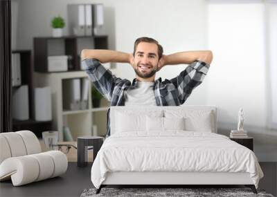 Attractive man with laptop in office Wall mural