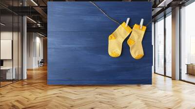 Baby socks hanging on dark blue background Wall mural