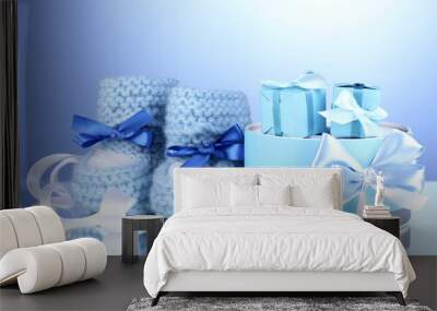 beautiful gifts and baby's bootees on blue background Wall mural