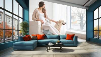 Beautiful pregnant woman with cute dog at home Wall mural