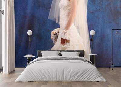 Beautiful woman with in  wedding dress over blue studio backgrou Wall mural