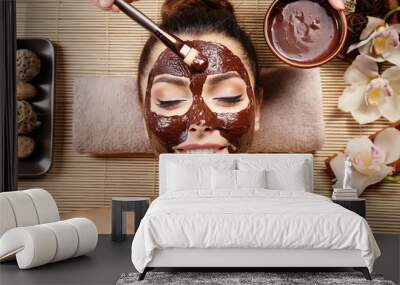 Beautiful young girl getting chocolate mask in spa salon Wall mural