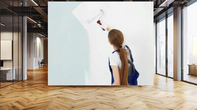 Beautiful young woman painting wall in room Wall mural