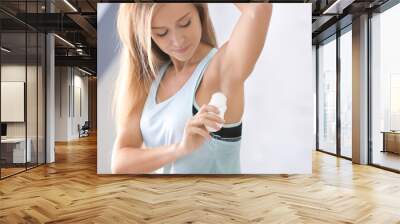 Beautiful young woman with deodorant at home Wall mural