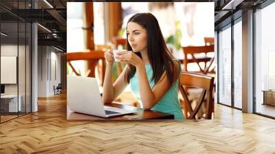 Beautiful young woman with laptop in cafe Wall mural