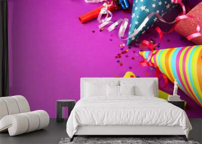 birthday hats with serpentine streamer and noise makers on purple background Wall mural