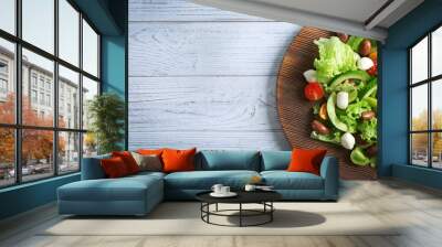 Board with delicious vegetable salad on wooden background Wall mural