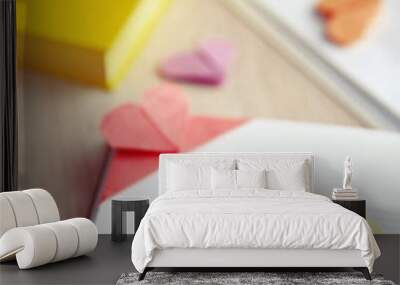 Books and heart shaped bookmarks on a light wooden background Wall mural