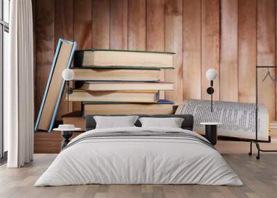 Books on wooden table on wooden wall background Wall mural