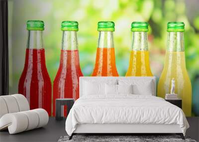 Bottles with tasty drinks on bright background Wall mural