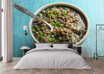 Bowl with tasty lentil dish and spoon on shabby wooden table, closeup Wall mural