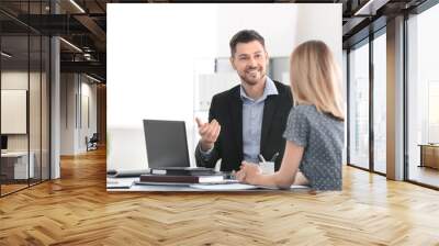 Businessman consulting young woman in office Wall mural