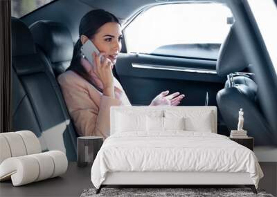 Businesswoman speaking by cellphone and riding a car Wall mural