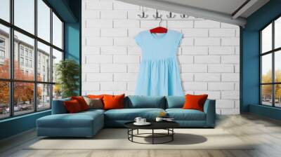 Child dress on hanger on white wall background Wall mural