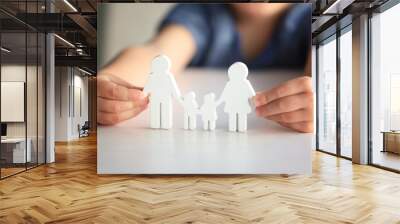 Child holding figure in shape of happy family, closeup. Adoption concept Wall mural