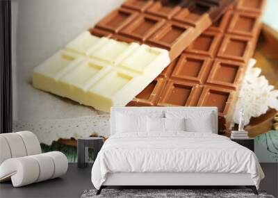 Chocolate bars on napkin, on tray, on wooden background Wall mural