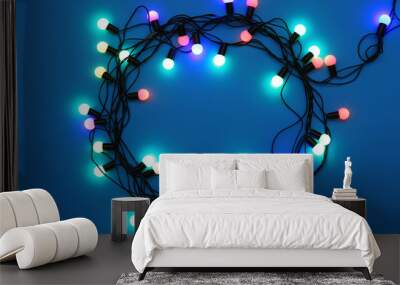 Circle of Christmas lights glowing on blue background Wall mural