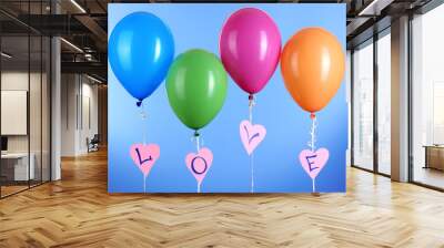 Colorful balloons keeps word love on blue background Wall mural