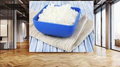 Cooked rice in bowl on wooden background Wall mural