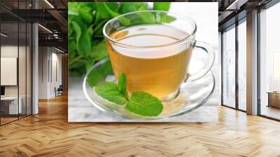 Cup of mint tea on wooden table Wall mural