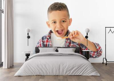 Cute African American boy eating yogurt on light background Wall mural