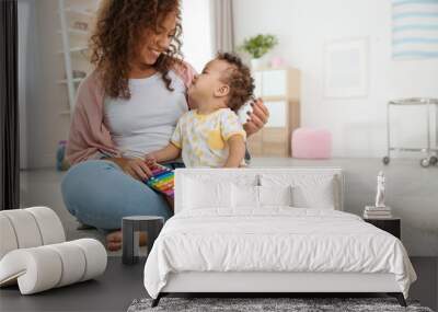 Cute baby and mother playing on floor at home Wall mural