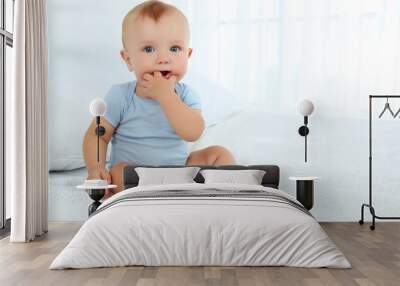 Cute baby boy on bed in room Wall mural