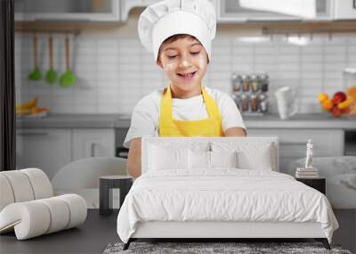 Cute boy cooking in kitchen at home Wall mural