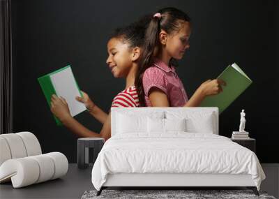 Cute girls reading book on grey background Wall mural