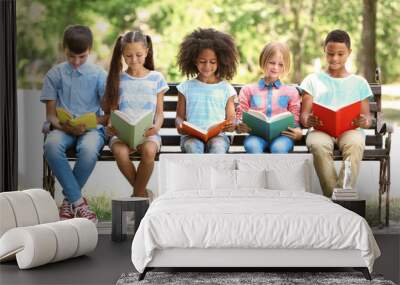 cute kids reading books on bench Wall mural