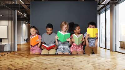 Cute kids reading books on grey background Wall mural