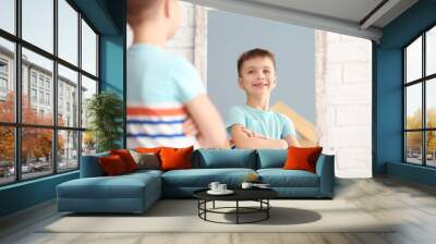 Cute little boy posing in front of mirror indoors Wall mural