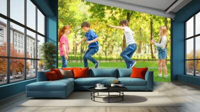 Cute little children jumping rope in park Wall mural