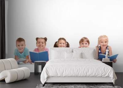 Cute little children reading books on white background Wall mural