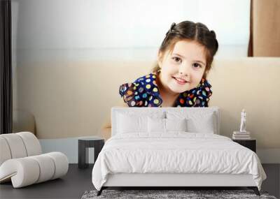 Cute little girl doing her homework, close-up, on home interior background Wall mural