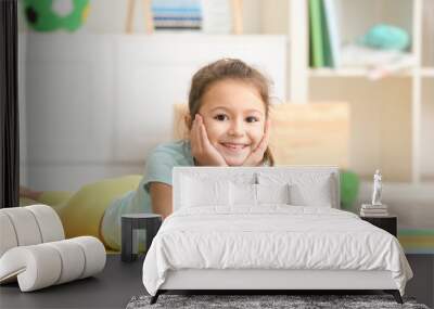 cute little girl lying on floor in kindergarten Wall mural